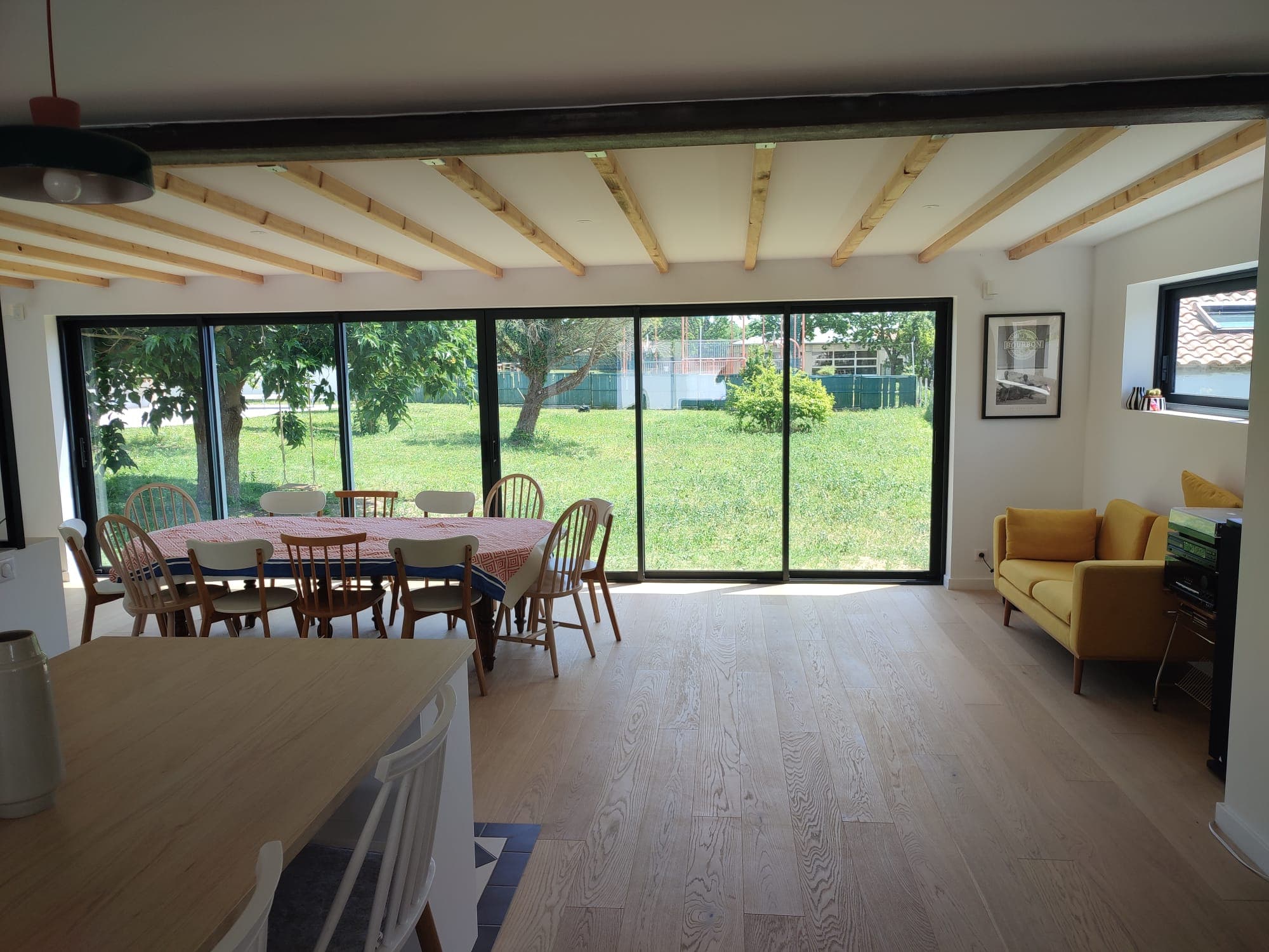 Salon, cuisine et salle à manger de la maison principale, ouverts sur le jardin